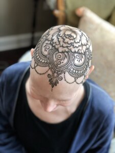 Henna tattoo mandala crown design on female scalp