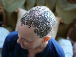 Henna tattoo crown design on female scalp