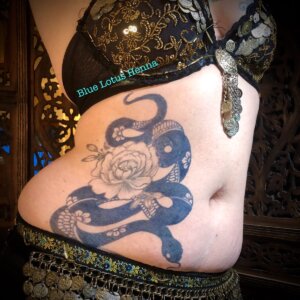 Belly dancer with jagua tattoo stain of snake and peony design on side torso