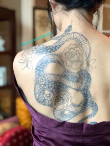 Jagua tattoo stain of snake and peonies on female shoulder blade/back