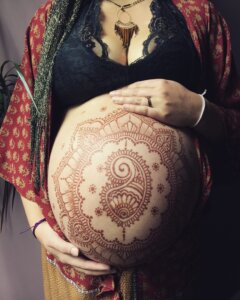 pregnant belly with intricate henna design on it
