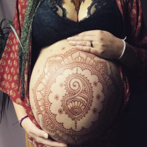 pregnant belly with intricate henna design on it