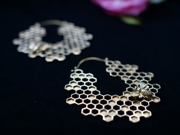 Honeycomb brass earrings with a small bee on them