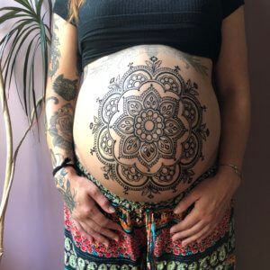 pregnant belly with a henna mandala drawn on it
